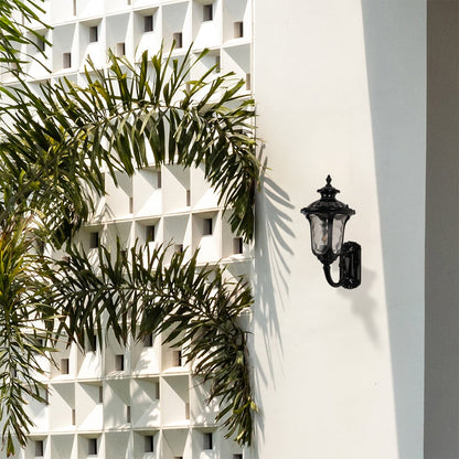 Stylish black outdoor wall lantern placed in an outdoor setting adding warm ambient light for porch pathway and garden decor.