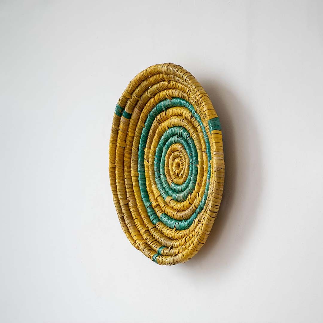 Side angle of artisan handwoven wall basket showing depth and weaving detail — eco-friendly handmade wall art for bohemian interiors.