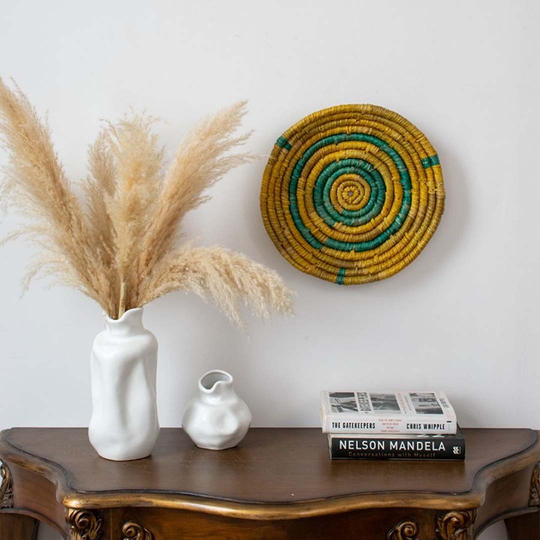 Handwoven wall basket displayed in a minimal living room setup with ceramic vases and dried pampas grass — perfect for modern boho home decor.