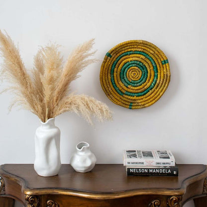 Handwoven wall basket displayed in a minimal living room setup with ceramic vases and dried pampas grass — perfect for modern boho home decor.