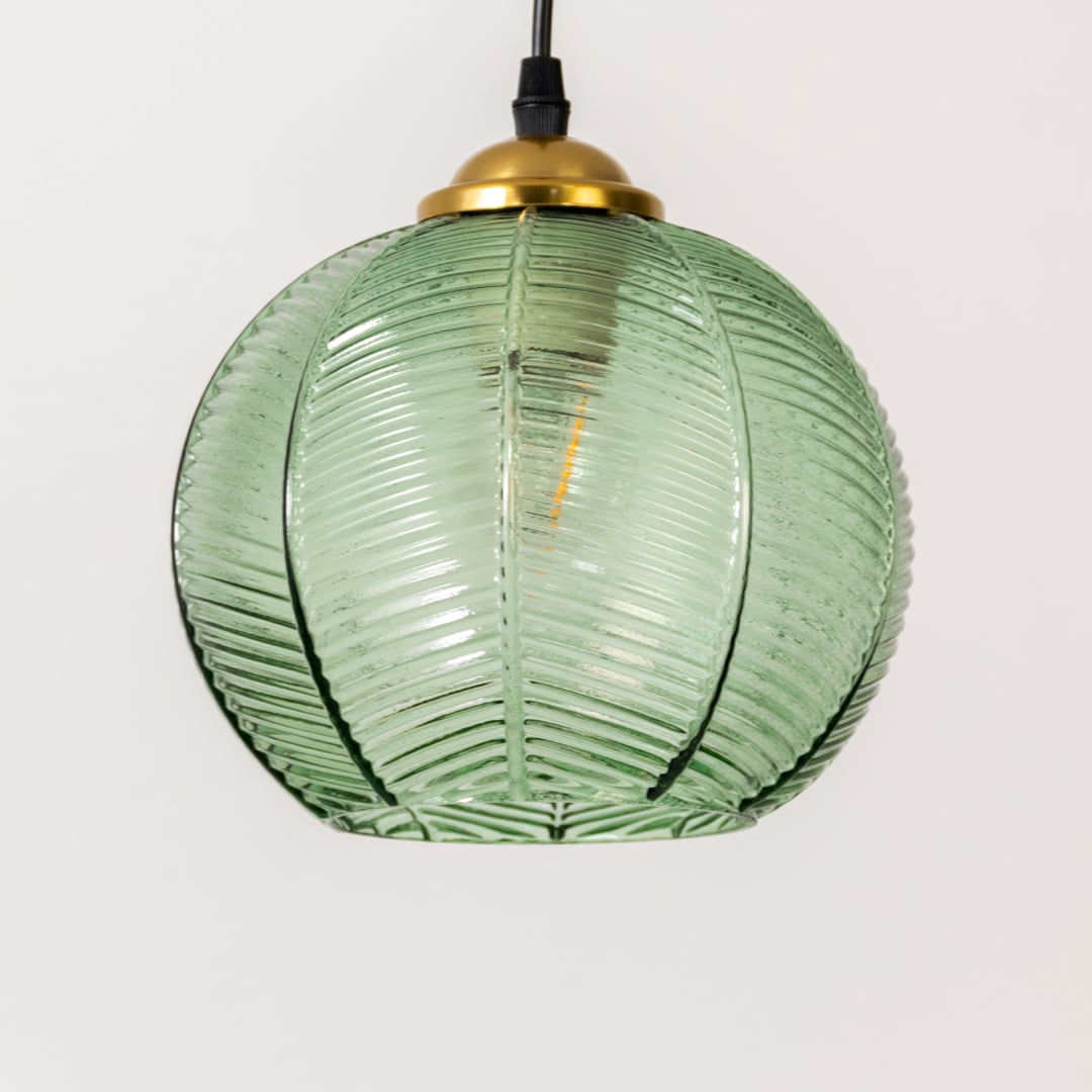 Detailed view of green ribbed glass and gold metal pendant light highlighting textured craftsmanship.