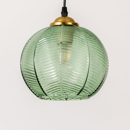 Detailed view of green ribbed glass and gold metal pendant light highlighting textured craftsmanship.