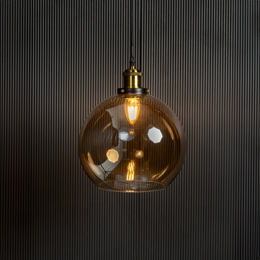 Amber glass pendant light with bulb on displayed on black background is premium pendant lighting.