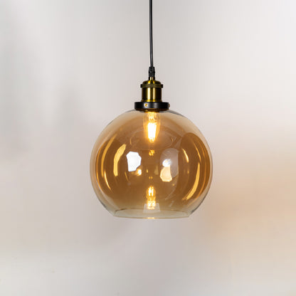 Amber glass globe pendant light with brass metal holder and contemporary design for elegant ceiling lighting decor.