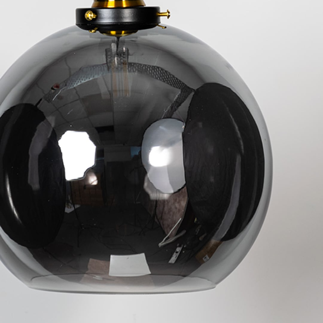 Closeup view of glass globe pendant light shows detailed lamp holder and clear finish for modern home decor lighting.