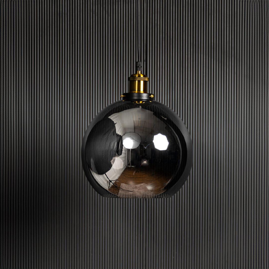 Glass globe pendant light turned off against black background is a stylish hanging ceiling lamp for home interiors.