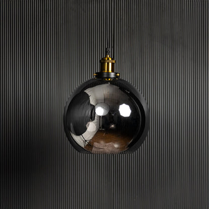 Glass globe pendant light turned off against black background is a stylish hanging ceiling lamp for home interiors.