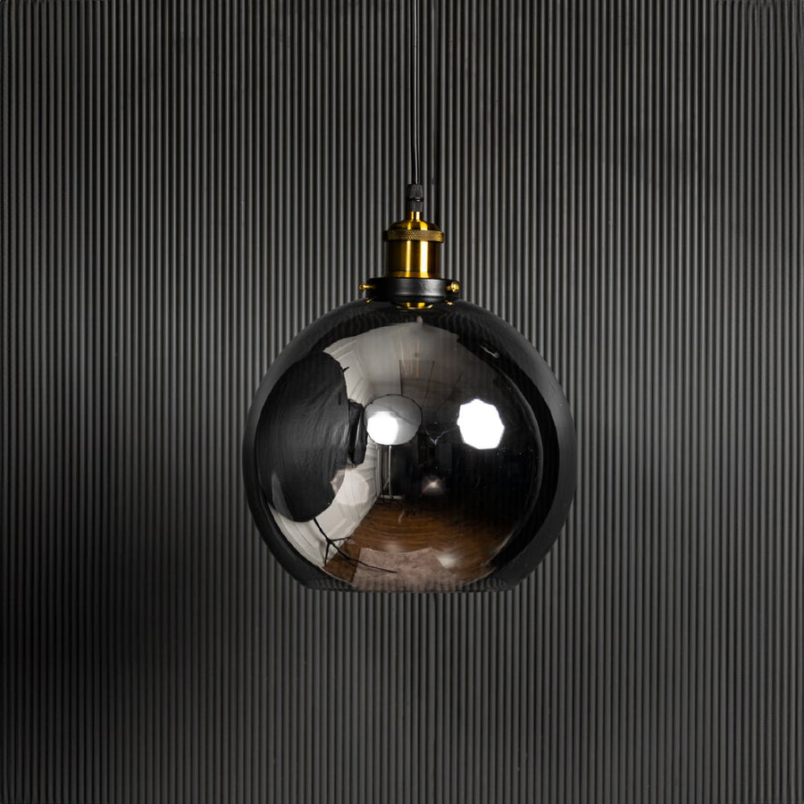 Glass globe pendant light turned off against black background is a stylish hanging ceiling lamp for home interiors.