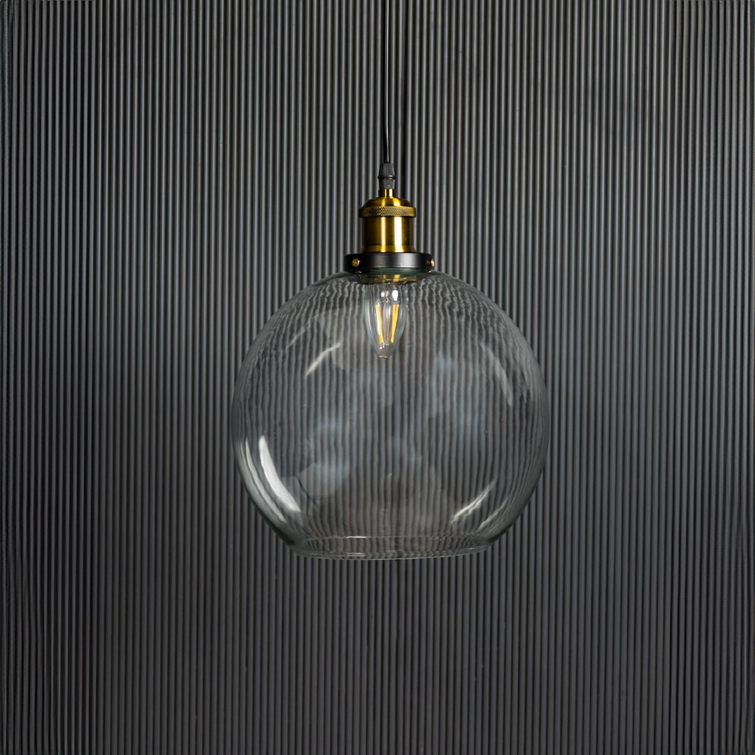 Clear glass globe pendant light with brass accents adding elegance to dining room ceilings.