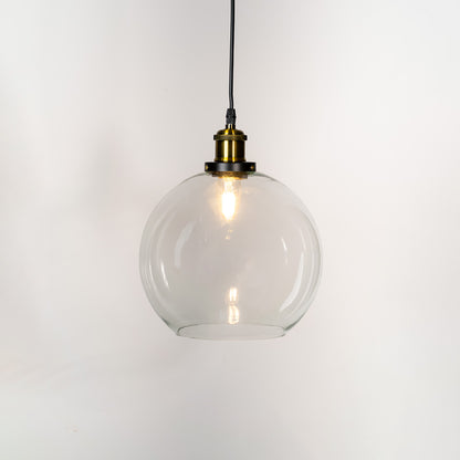 Clear glass pendant light with brass finish metal holder and globe design for elegant modern ceiling lighting decor.