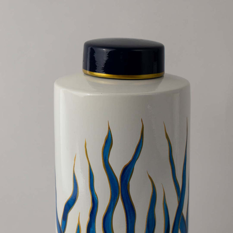 Closeup of ceramic decor jar showing detailed blue wave artwork and glossy finish with elegant golden lid accent.