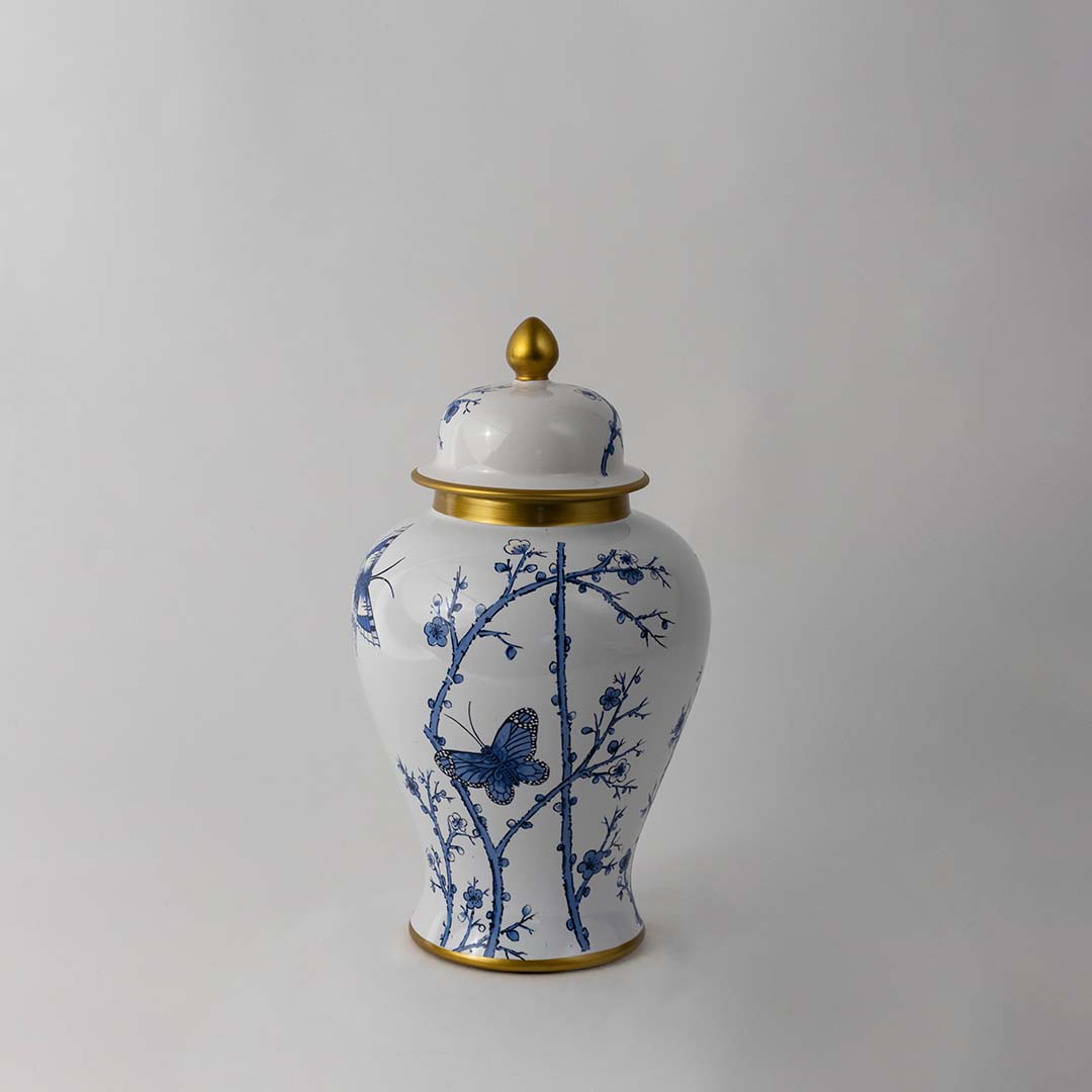 Handcrafted ceramic jar with blue floral butterfly pattern and golden lid perfect for classic home decor styling.