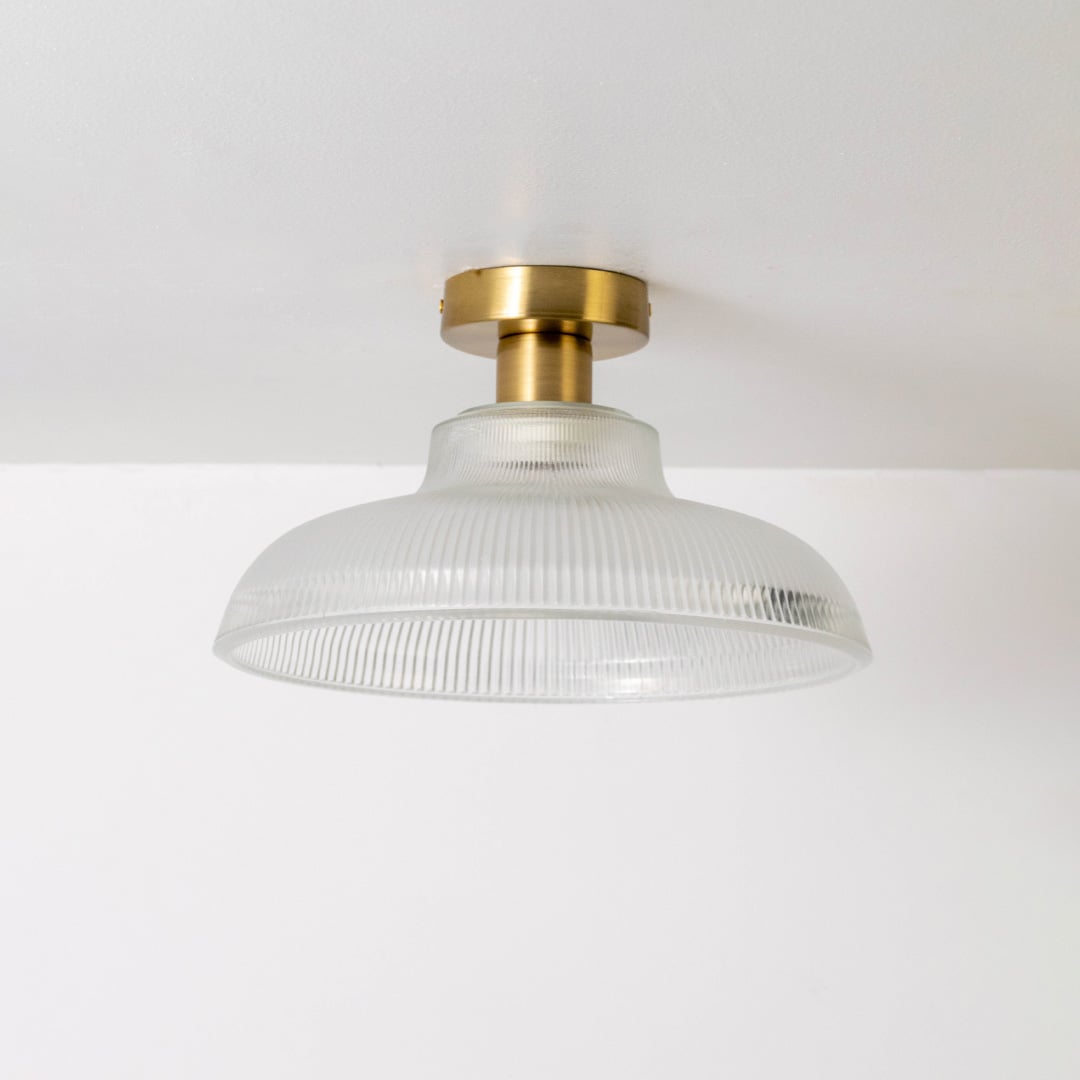 Modern white ribbed glass and gold metal ceiling light for elegant bedroom and traditional decor styling spaces.
