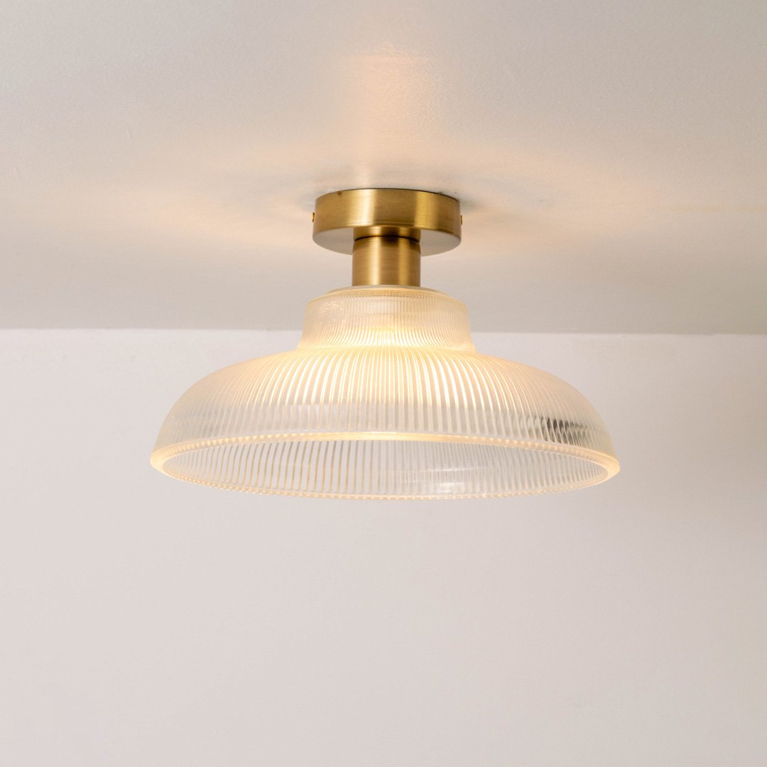 Closeup of clear ribbed glass and gold metal ceiling light for luxury interior decor and premium styling spaces.