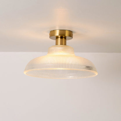 Closeup of clear ribbed glass and gold metal ceiling light for luxury interior decor and premium styling spaces.