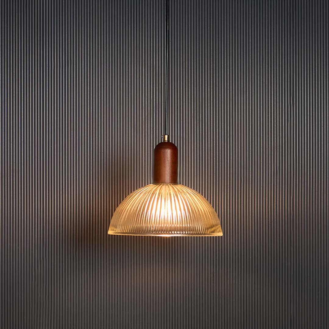 Amber glass pendant light glowing warmly with copper accents for luxurious dining room decor.