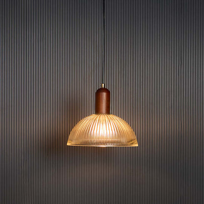 Amber glass pendant light glowing warmly with copper accents for luxurious dining room decor.