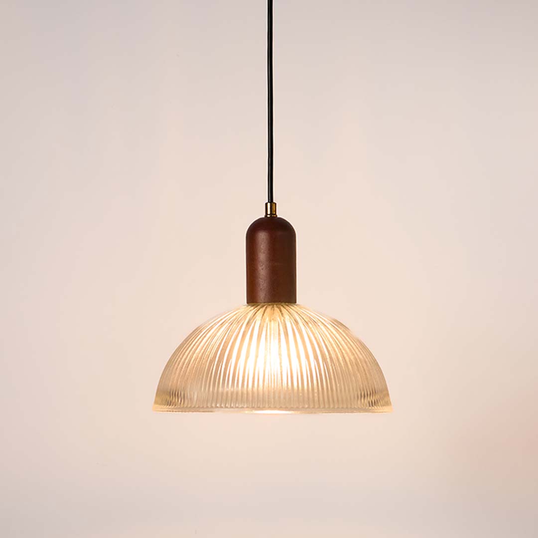 Ribbed clear glass and walnut wood pendant light with warm glow for elegant modern home decor spaces.