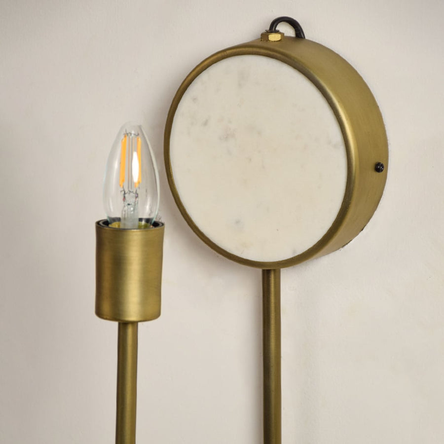 Closeup of marble and gold metal wall light for stylish bedroom and premium decor styling spaces.

