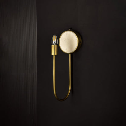 Metal and marble wall light shown unlit on dark background emphasizing minimalist design and golden finish for luxurious interior decor.
