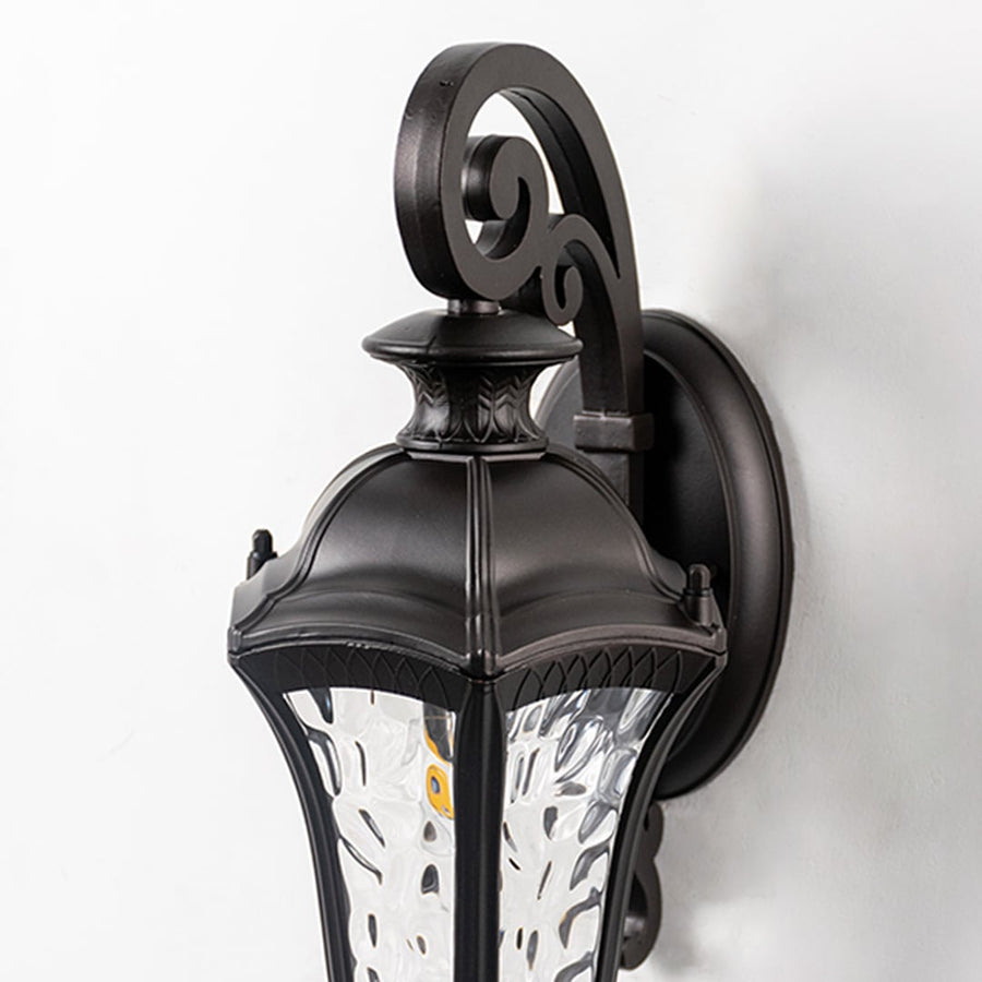 Closeup of lantern wall light with textured glass panels and detailed curved arm showcases fine craftsmanship.