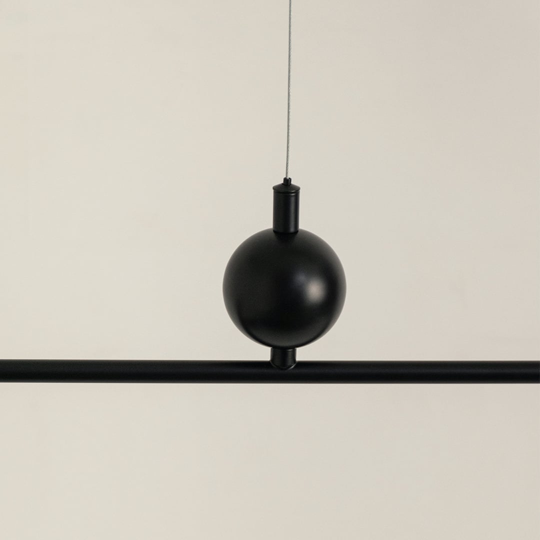 Black metal pendant light with decorative sphere accent highlighting refined metal craftsmanship and modern design appeal.