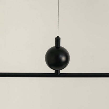 Black metal pendant light with decorative sphere accent highlighting refined metal craftsmanship and modern design appeal.