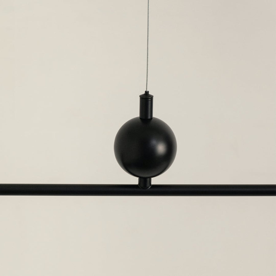 Black metal pendant light with decorative sphere accent highlighting refined metal craftsmanship and modern design appeal.