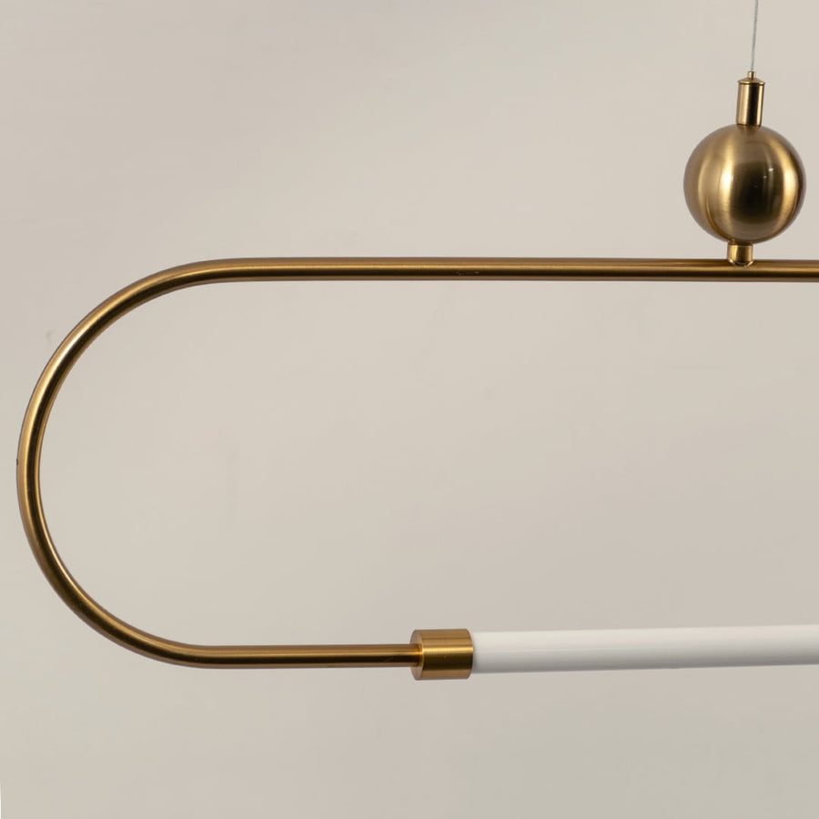 Detailed closeup of gold linear pendant light showing smooth metal finish rounded corners and white diffuser tube.