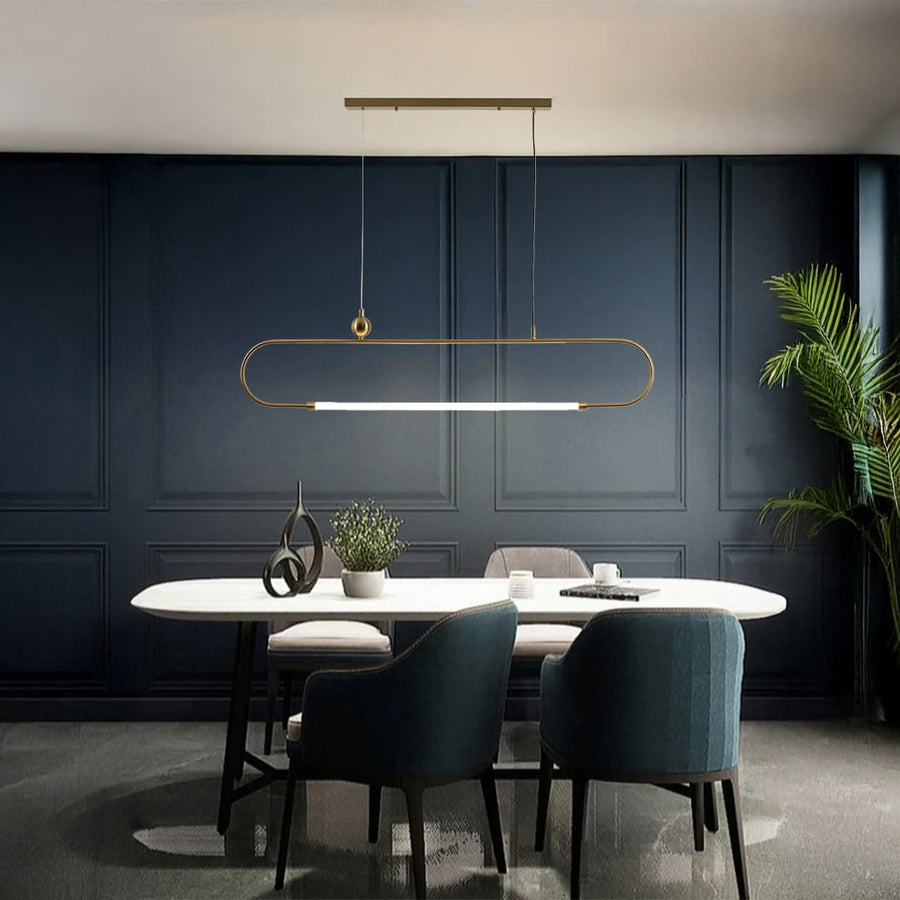 Gold metal linear pendant light with white diffuser styled in a modern interior adding warm elegant ambient lighting.