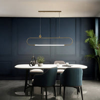 Gold metal linear pendant light with white diffuser styled in a modern interior adding warm elegant ambient lighting.