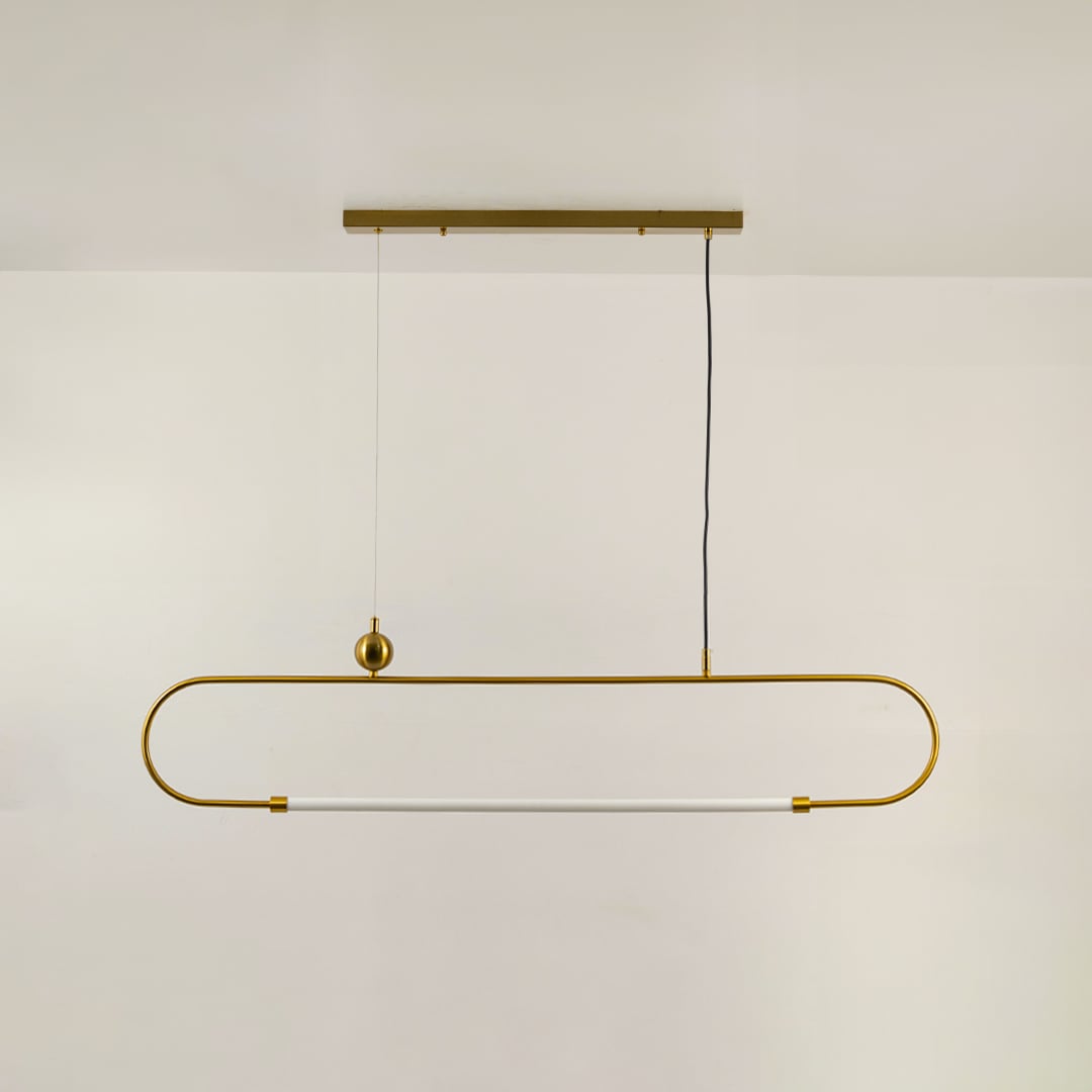 Gold metal linear pendant light on a white background with the light off highlighting its sculptural modern silhouette.