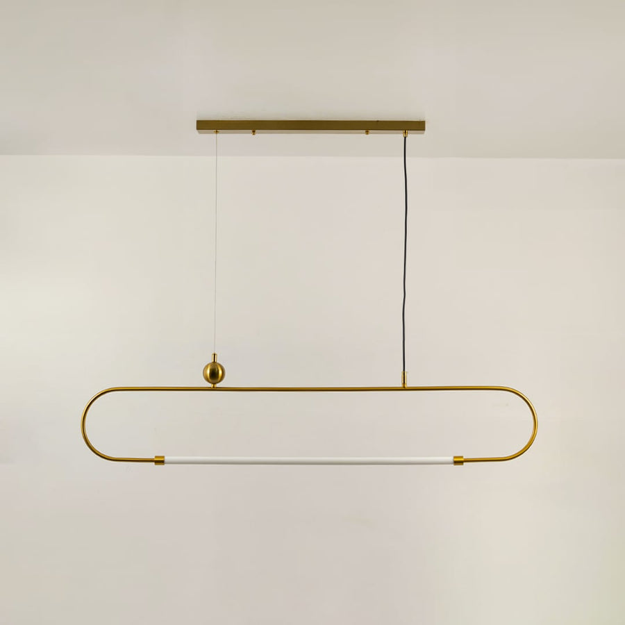 Gold metal linear pendant light on a white background with the light off highlighting its sculptural modern silhouette.