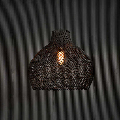 Black rattan pendant light glowing softly on dark background creating cozy ambience with elegant handcrafted design.