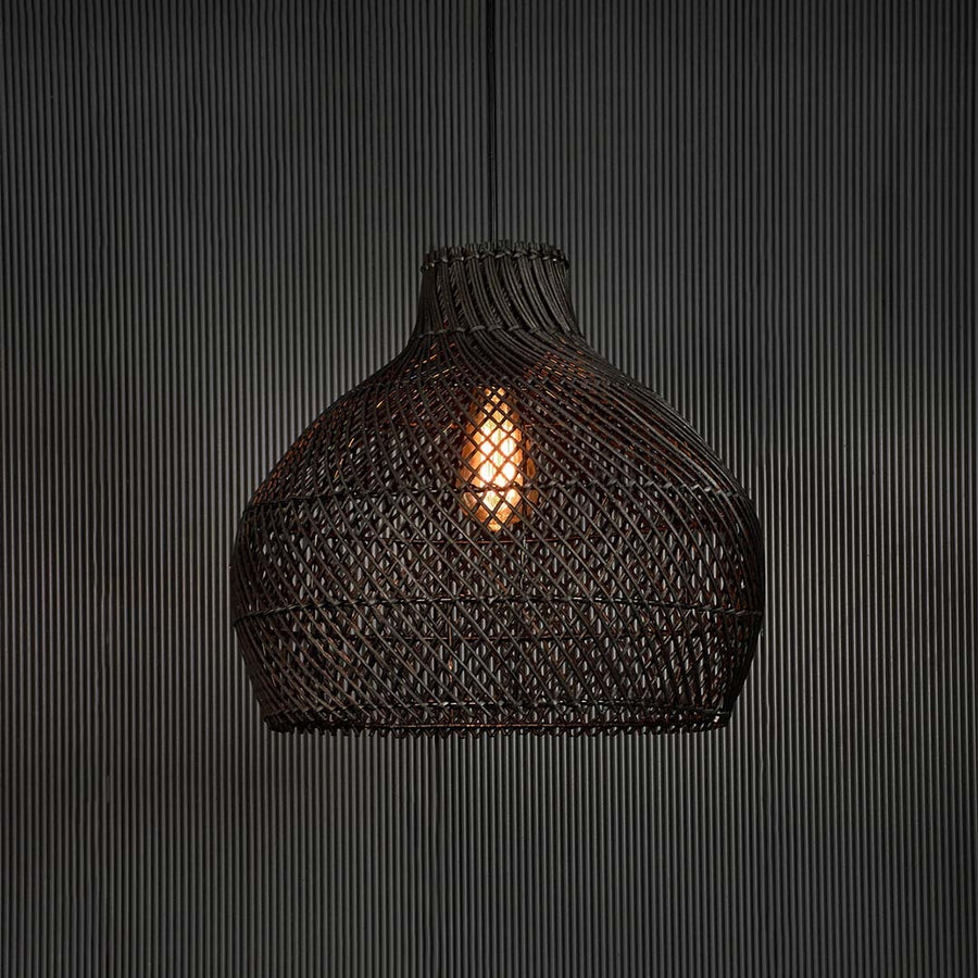 Black rattan pendant light glowing softly on dark background creating cozy ambience with elegant handcrafted design.