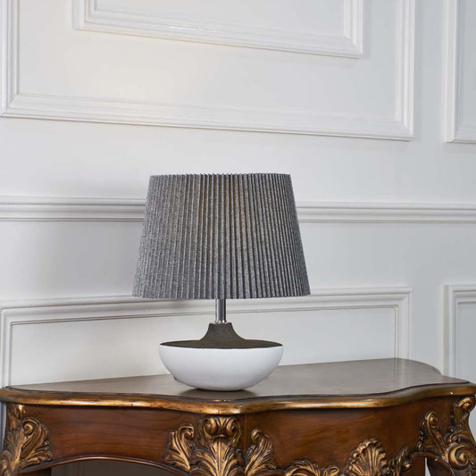 Grey ceramic table lamp with pleated fabric shade and bowl shaped base crafted for sophisticated modern table lighting.