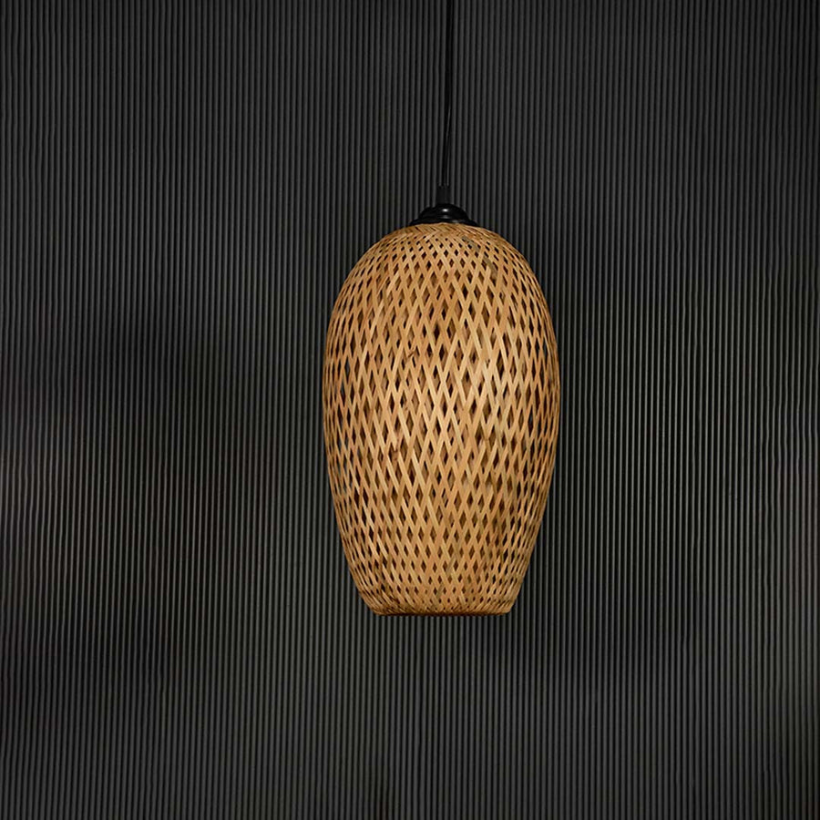 Bamboo pendant light bulb off on black background with tall oval wicker shade design for bohemian modern lighting.