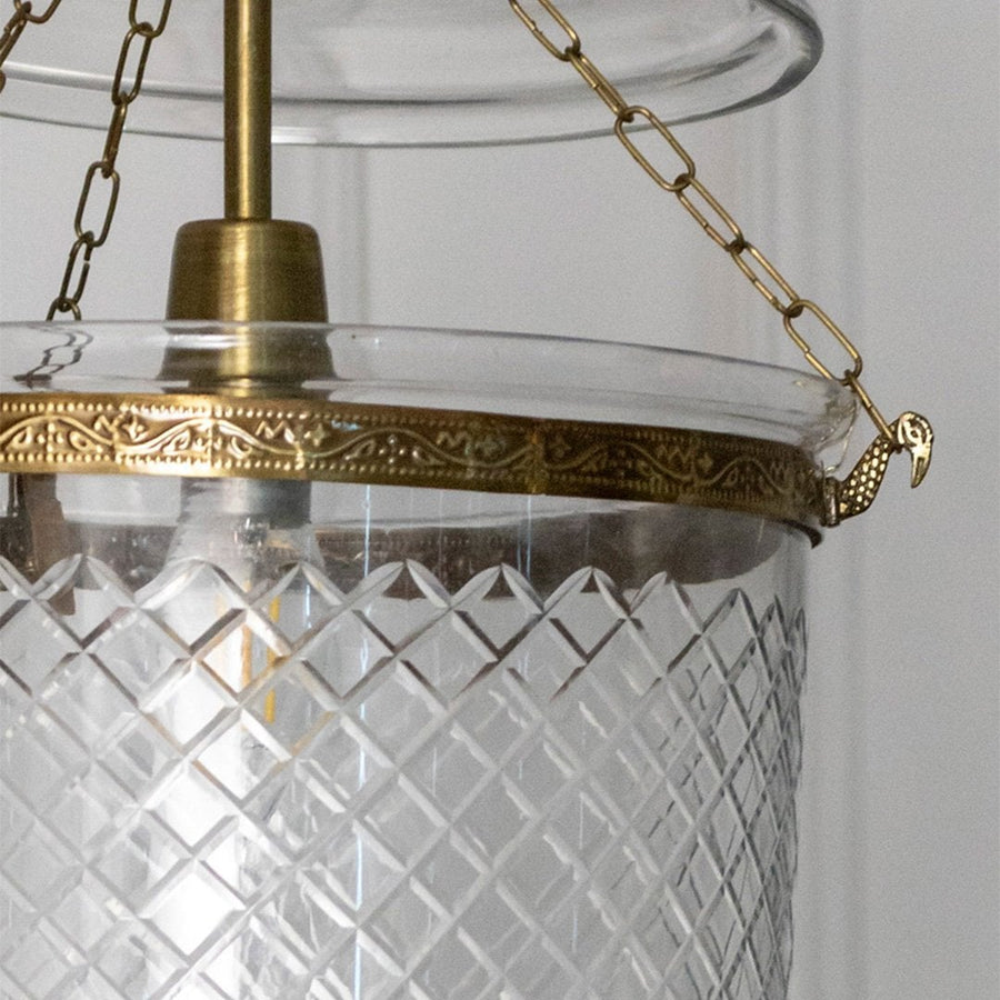 Closeup of antique metal pendant light with textured glass shade showcasing detailed craftsmanship and premium finish.