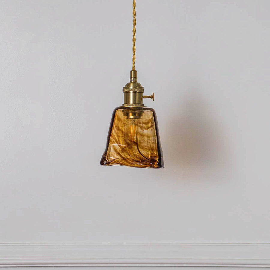 Amber textured glass pendant light with polished gold fittings crafted for elegant home interiors.