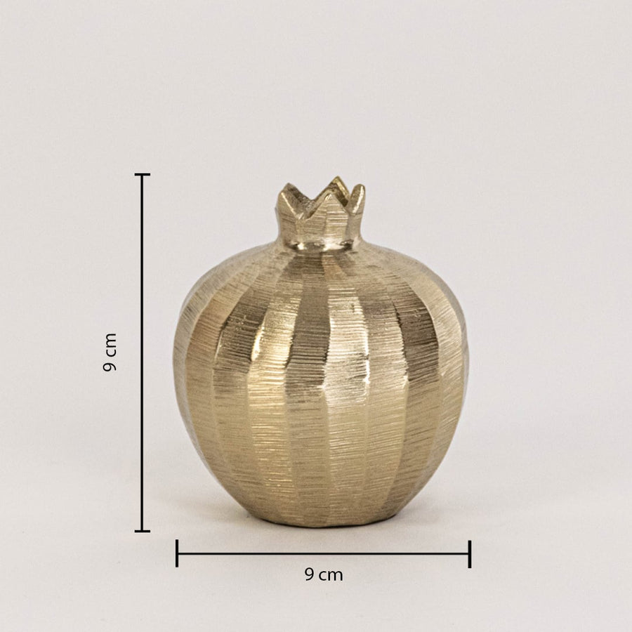 Gold pomegranate decor piece measuring 9 cm tall and 9 cm wide with textured finish shown on plain white backdrop.