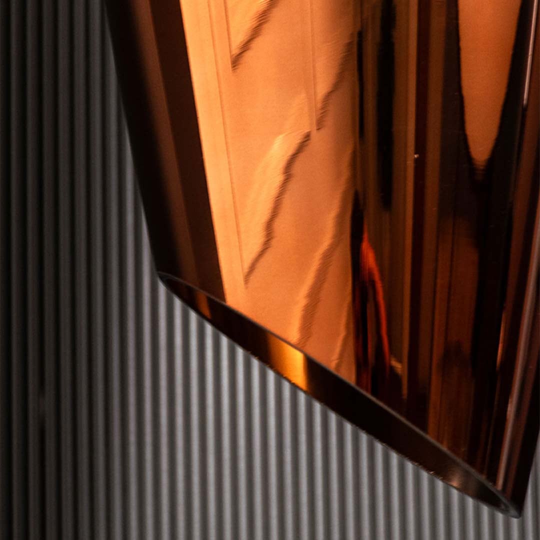 A closeup view of the bronze glass pendant light showing the reflective curved tinted glass and warm glow ideal for modern luxury interiors.