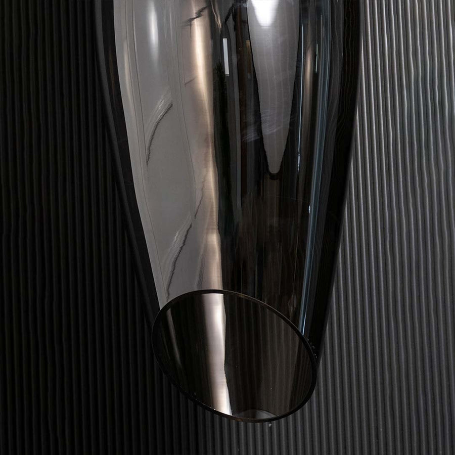 A closeup view of the smoked black pendant light showing the smooth curved glass surface and warm reflective glow ideal for premium interiors.
