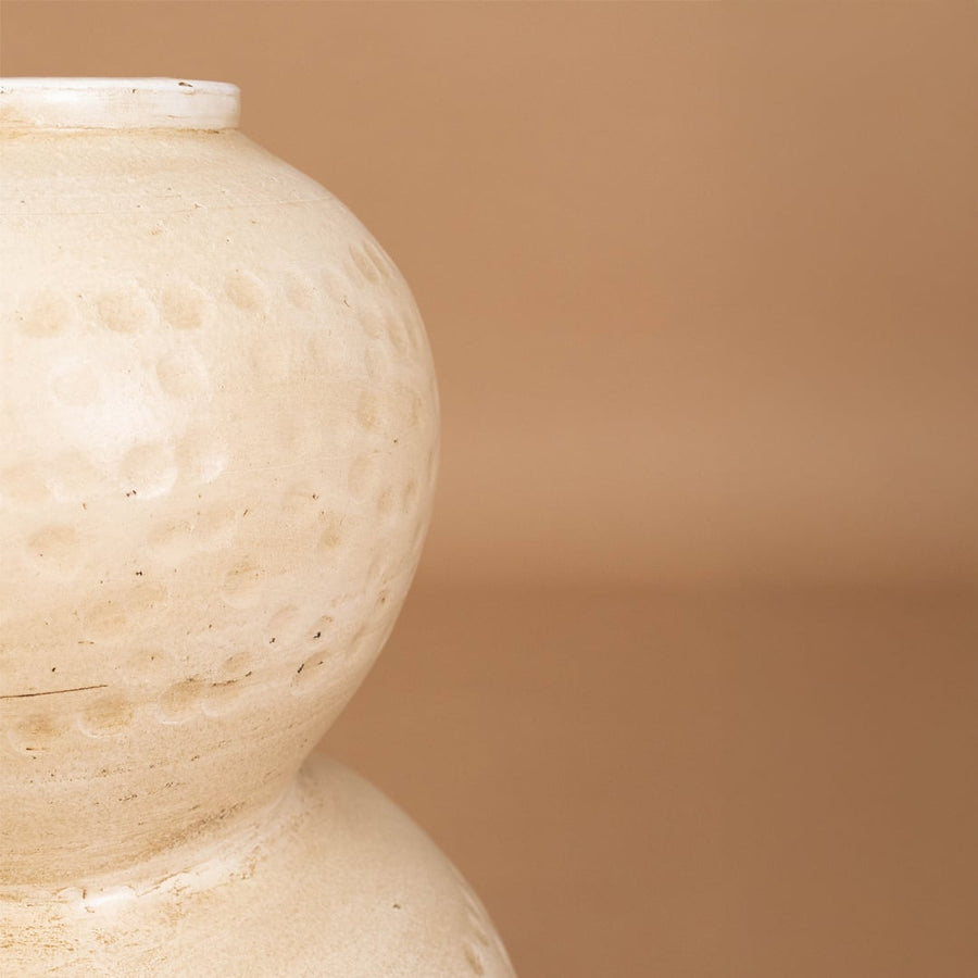 Closeup of beige textured decorative vase showing detailed sculpted surface and handcrafted finish ideal for modern artistic home decor.
