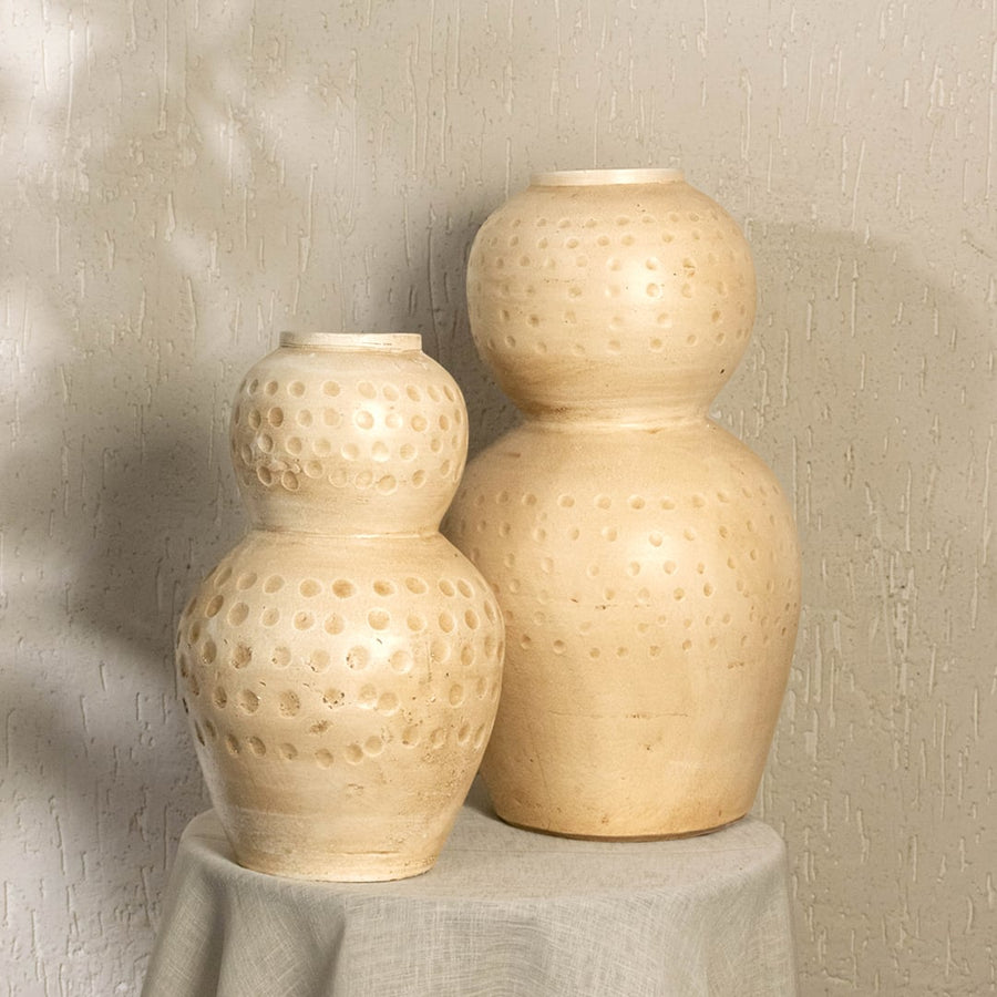 Cream textured decorative vase with polka dot pattern styled in a warm modern room adding artistic earthy decor to living rooms hallways and interiors.
