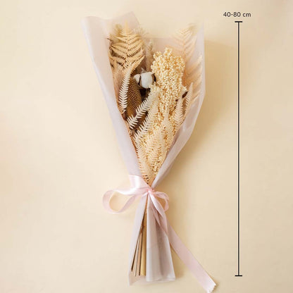 Rustic dried flower bouquet with pampas grass cotton stems preserved amaranthus and fern leaves tied with pink ribbon on plain background.