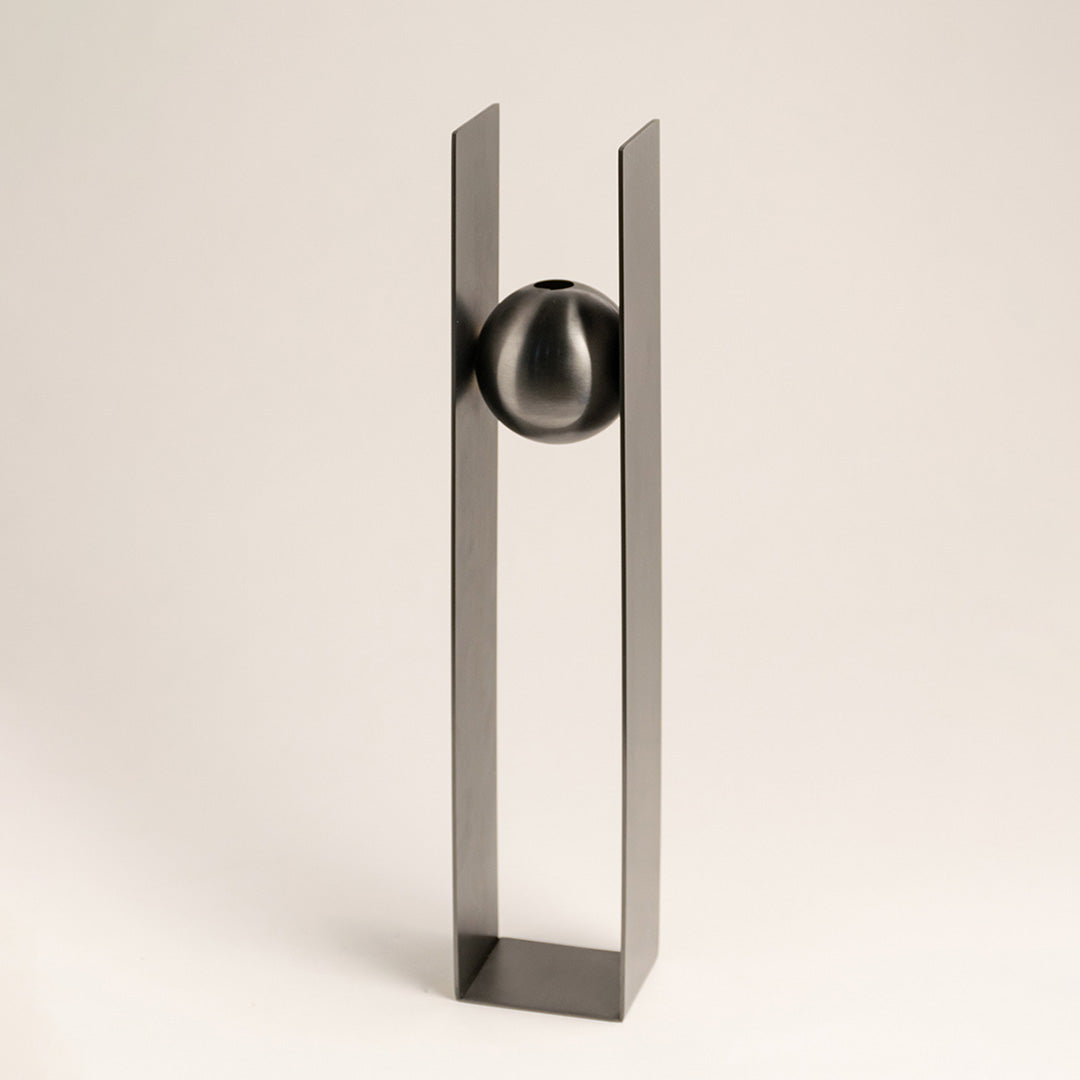 Silver metal decorative sculpture with geometric frame and sphere accent for contemporary tabletop styling and decor.