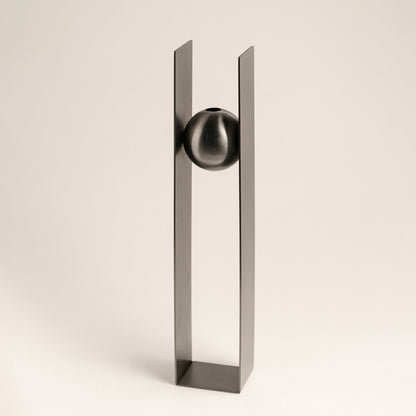 Silver metal decorative sculpture with geometric frame and sphere accent for contemporary tabletop styling and decor.