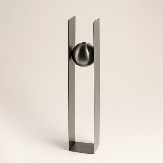 Silver metal decorative sculpture with geometric frame and sphere accent for contemporary tabletop styling and decor.