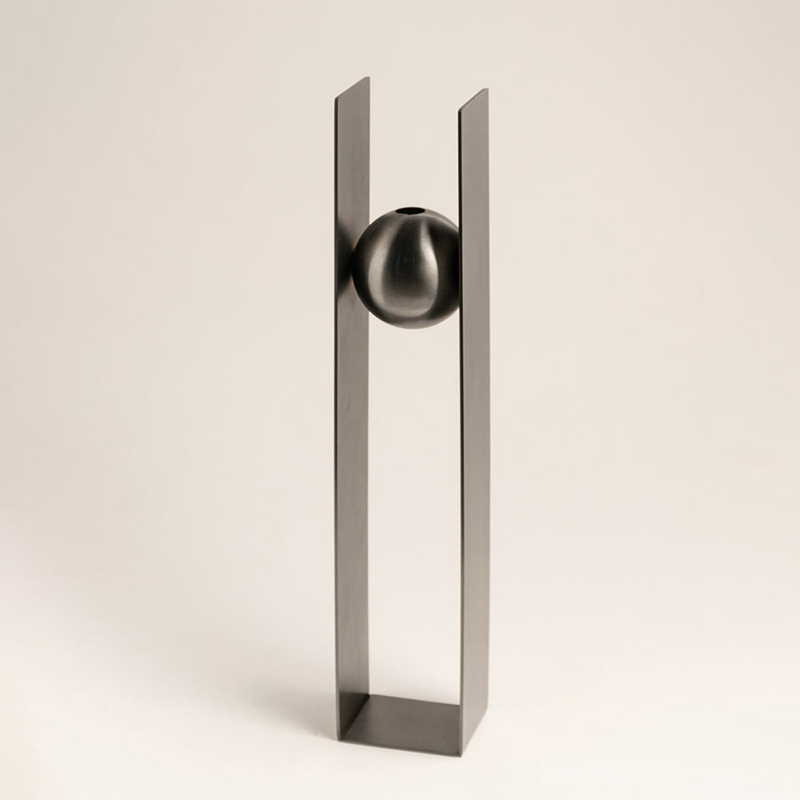 Silver metal decorative sculpture with geometric frame and sphere accent for contemporary tabletop styling and decor.