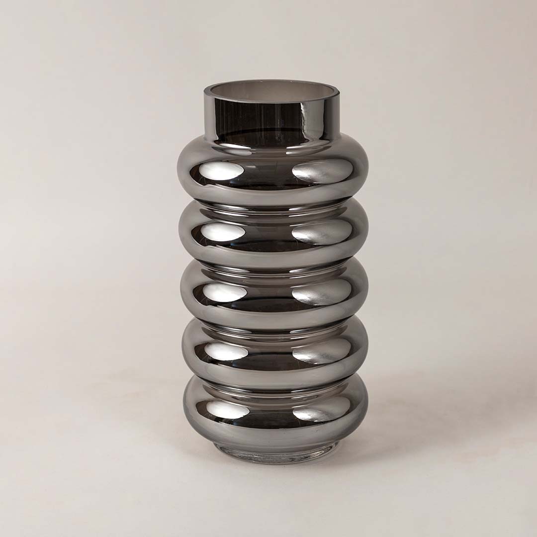 Ripple textured smoky glass vase photographed on white surface showcasing sleek glossy finish and curved modern form.